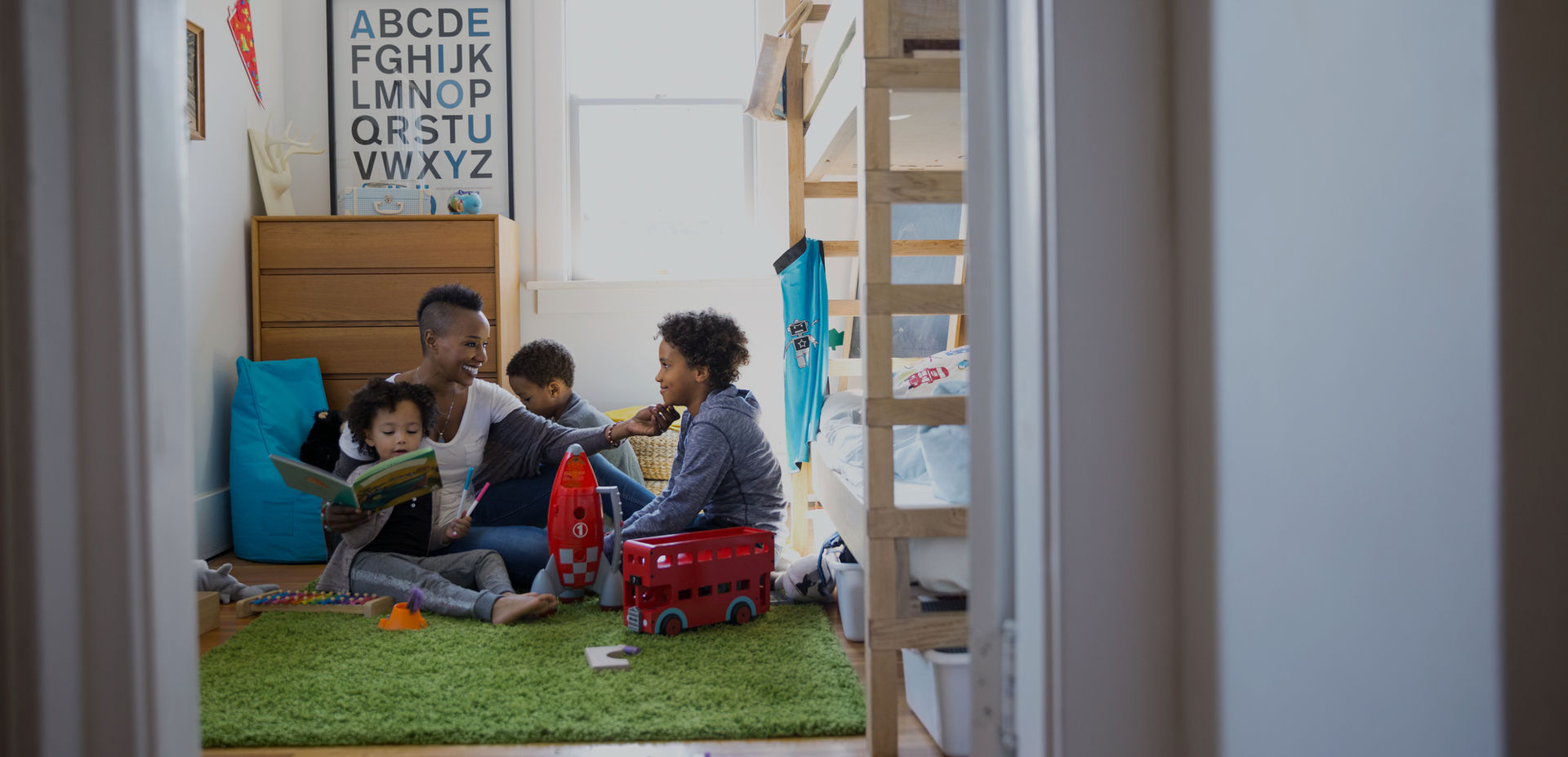 Mother playing with children in comfortable home setting with bunk beds and toys