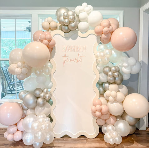 Wavy event backdrop with peach, silver, and white balloons