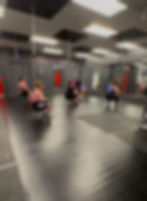 Bungee fitness class performing squats with overhead bungee equipment