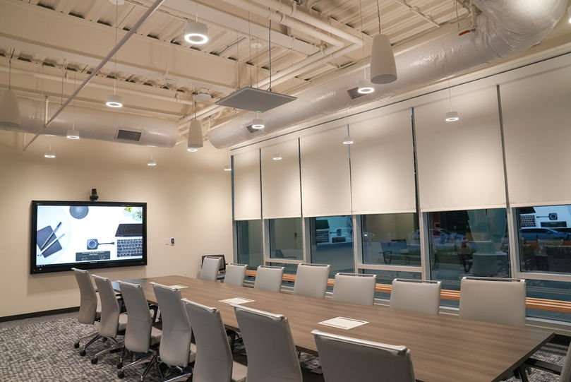 Conference room with long table and wall-mounted display screen