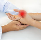 Doctor examining patient’s hand with arthritis for red light therapy treatment