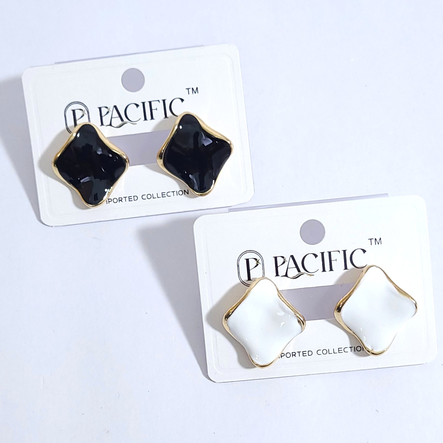 Pair of wavy geometric enamel stud earrings with gold borders in black and white options.