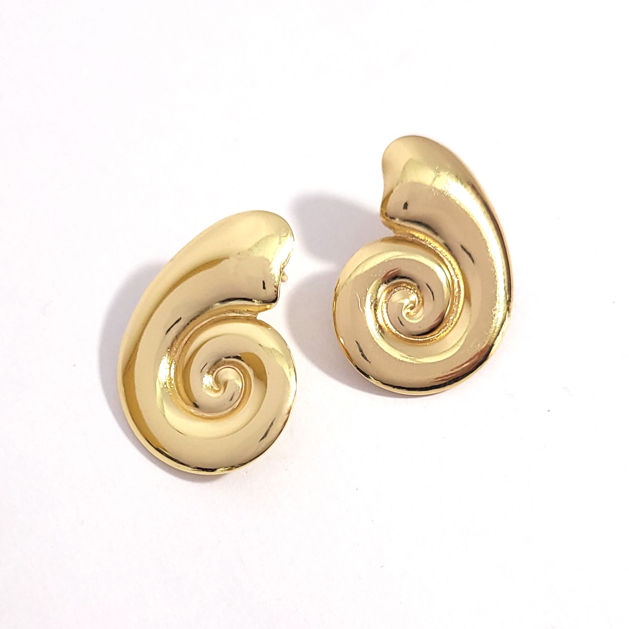 Pair of high-polish gold nautilus spiral stud earrings on a white background.