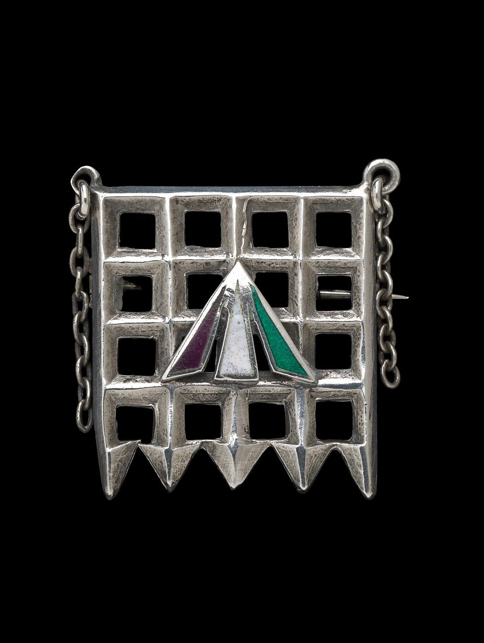 - Sylvia Pankhurst, "Holloway brooch", 1909. Broche sufragista de la prisión femenina Holloway, silver enamel. TOYE & CO., London (manufacturer). NGV, Melbourne.