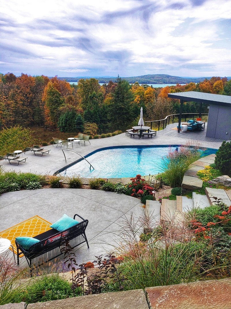 High-end pool with elevated spa and scenic mountain backdrop in upstate NY