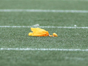 yellow penalty flag on football field