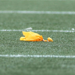 yellow penalty flag on football field