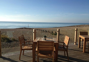 Table and chairs on the beach with a sea view