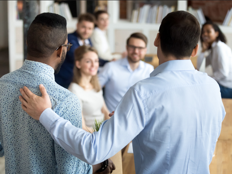A boss puts his hands around his new hire in celebration