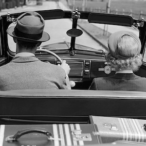 a man and a woman are sitting in the back seat of a car .
