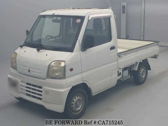 A grey JDM sports car speeding down a highway at night.