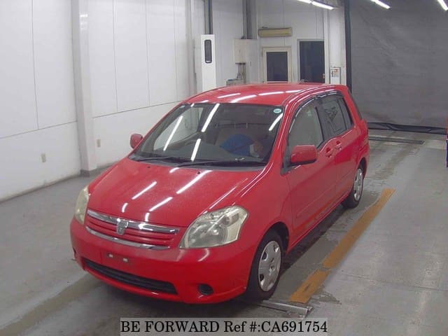 A grey JDM sports car speeding down a highway at night.