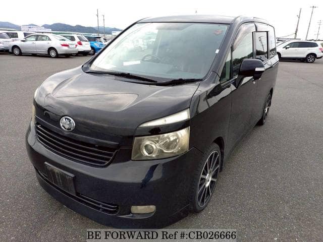 A grey JDM sports car speeding down a highway at night.