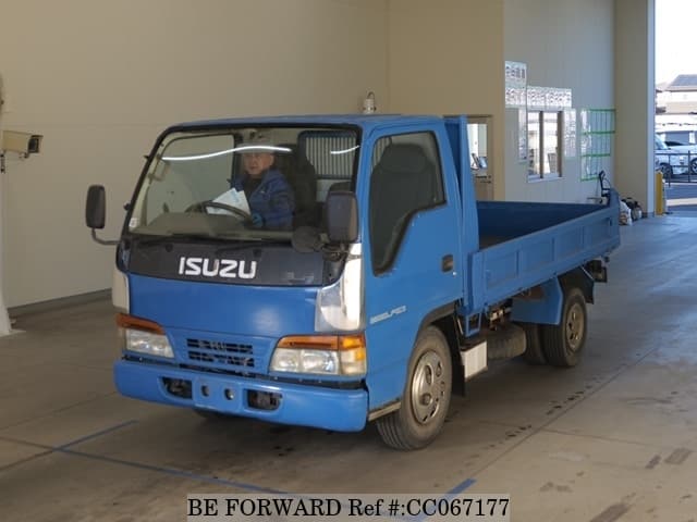 A grey sports car speeding down a highway at night.