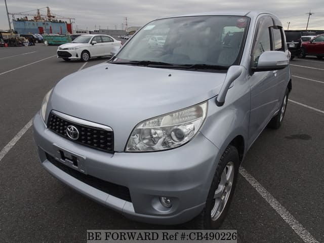 A grey JDM sports car speeding down a highway at night.