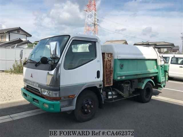 A grey JDM sports car speeding down a highway at night.