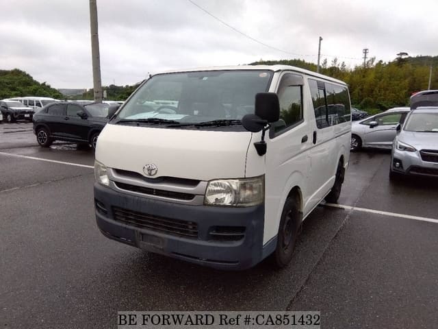 A grey JDM sports car speeding down a highway at night.