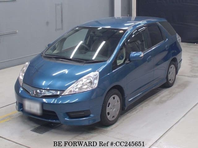 A grey sports car speeding down a highway at night.