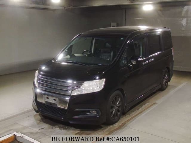 A grey JDM sports car speeding down a highway at night.