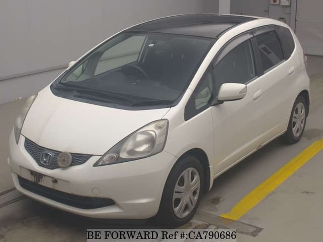 A grey JDM sports car speeding down a highway at night.