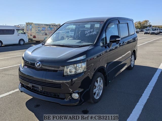 A grey JDM sports car speeding down a highway at night.