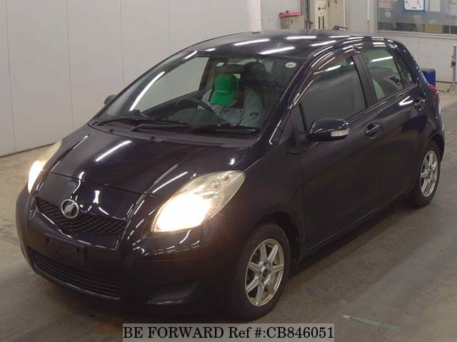 A grey JDM sports car speeding down a highway at night.