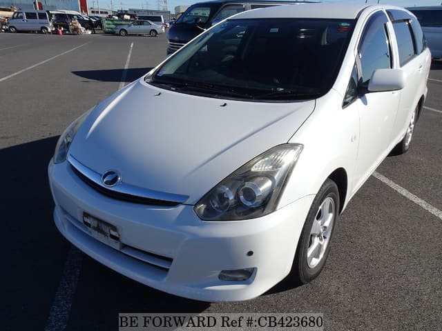 A grey JDM sports car speeding down a highway at night.