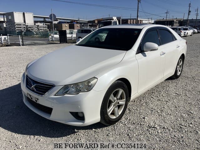 A grey sports car speeding down a highway at night.