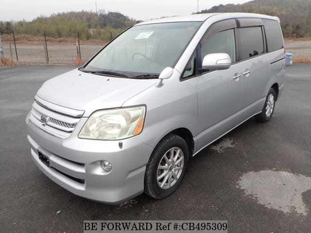 A grey JDM sports car speeding down a highway at night.