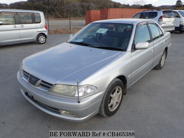 A grey JDM sports car speeding down a highway at night.