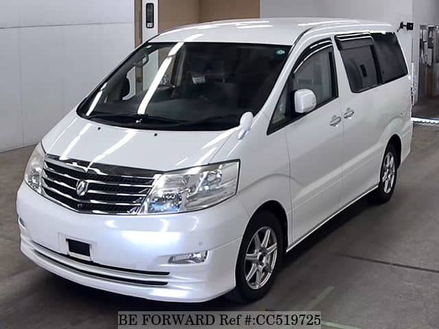 A grey sports car speeding down a highway at night.