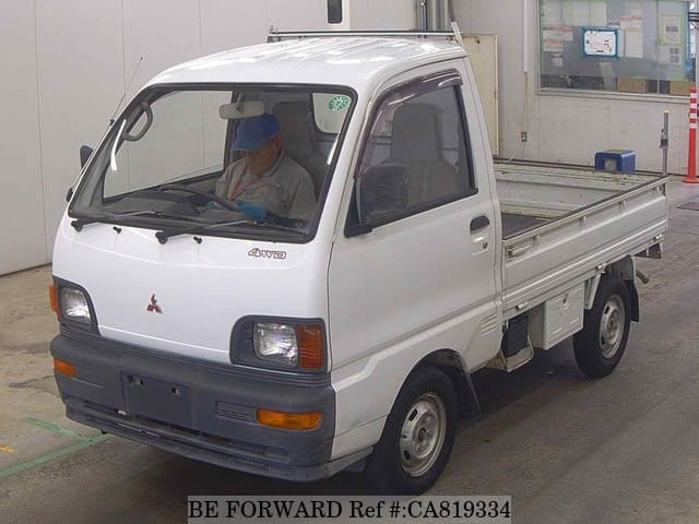 A grey JDM sports car speeding down a highway at night.