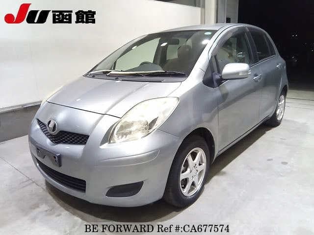 A grey JDM sports car speeding down a highway at night.