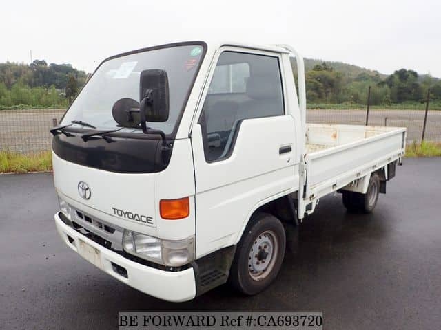 A grey JDM sports car speeding down a highway at night.