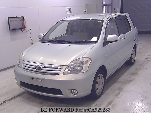 A grey sports car speeding down a highway at night.
