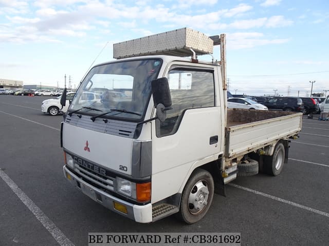 A grey JDM sports car speeding down a highway at night.