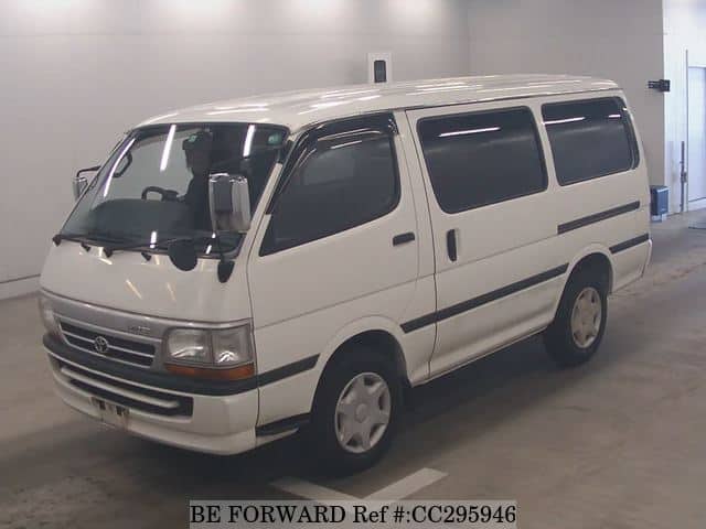 A grey sports car speeding down a highway at night.