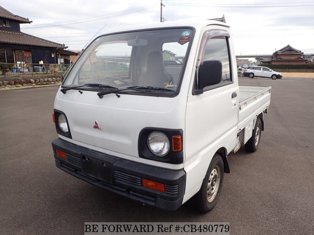 A grey JDM sports car speeding down a highway at night.