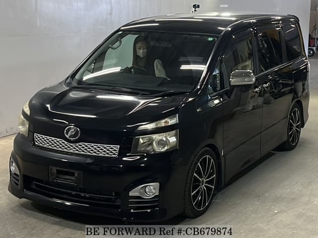 A grey JDM sports car speeding down a highway at night.