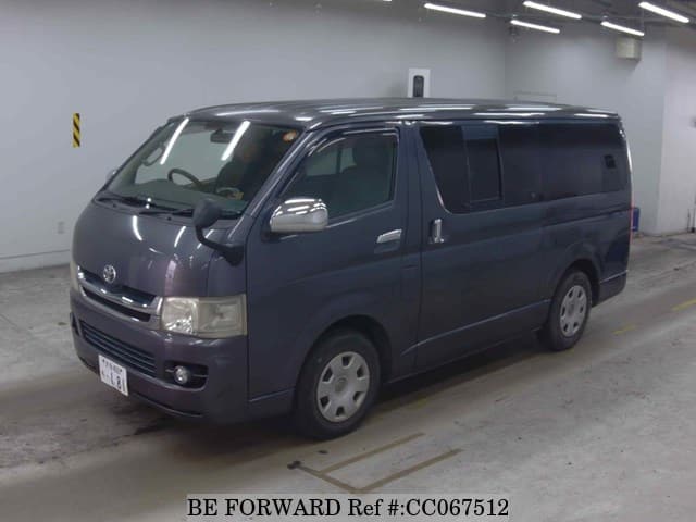 A grey sports car speeding down a highway at night.
