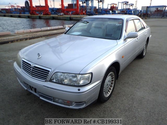 A grey sports car speeding down a highway at night.