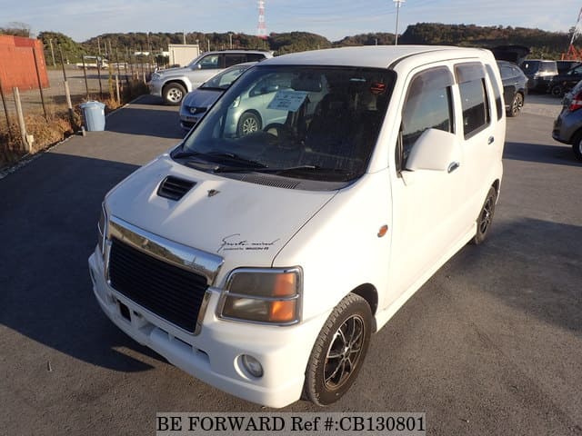 A grey JDM sports car speeding down a highway at night.