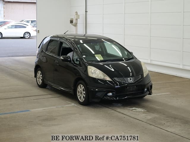 A grey JDM sports car speeding down a highway at night.