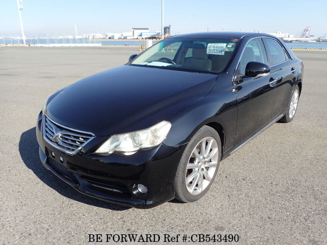 A grey JDM sports car speeding down a highway at night.