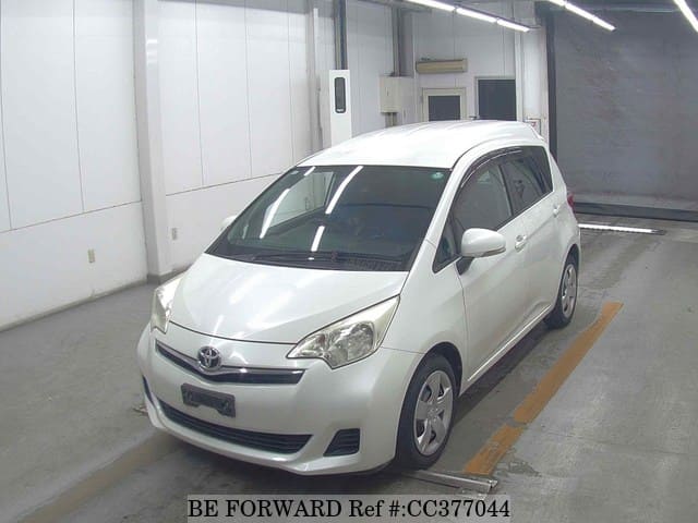 A grey sports car speeding down a highway at night.