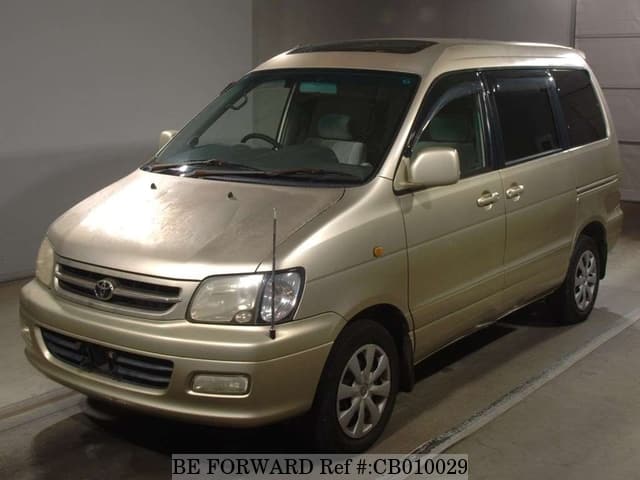 A grey JDM sports car speeding down a highway at night.