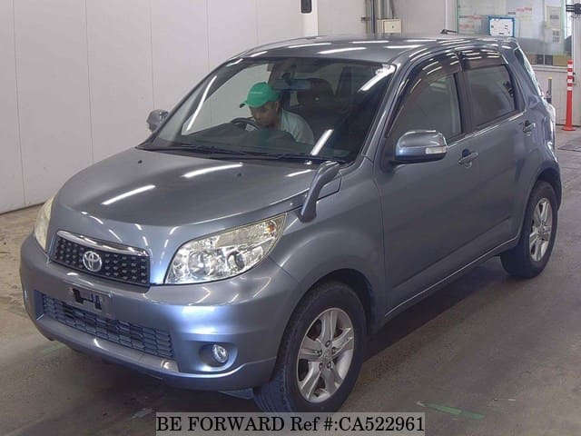 A grey JDM sports car speeding down a highway at night.