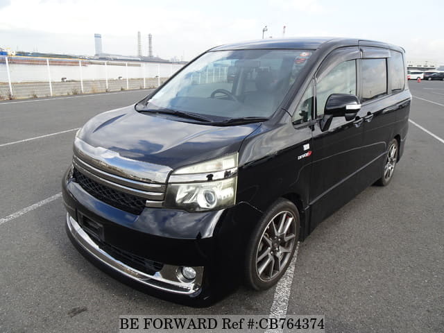 A grey JDM sports car speeding down a highway at night.