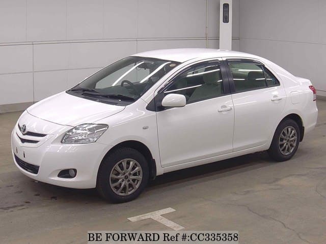 A grey sports car speeding down a highway at night.