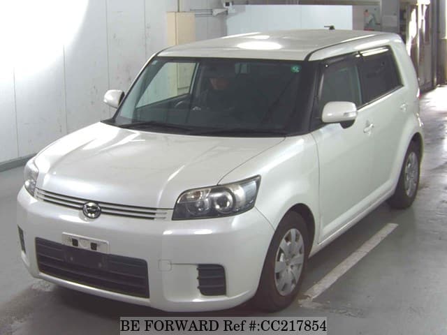 A grey sports car speeding down a highway at night.